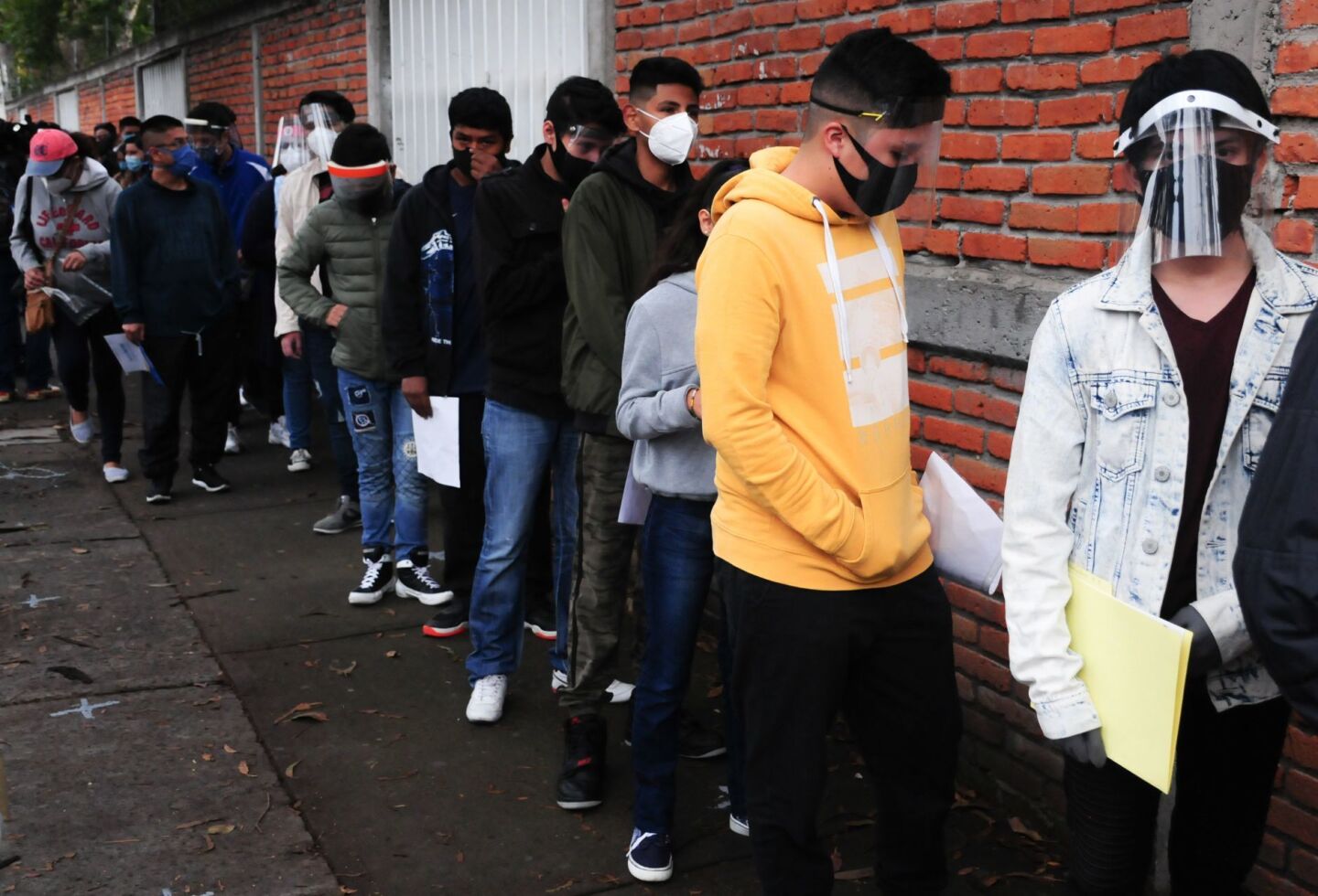 Jóvenes hacen una fila para poder ingresar al plantel y realizar su prueba Comipems.