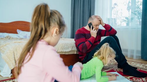 Tired dad with his two kids during quarantine.
