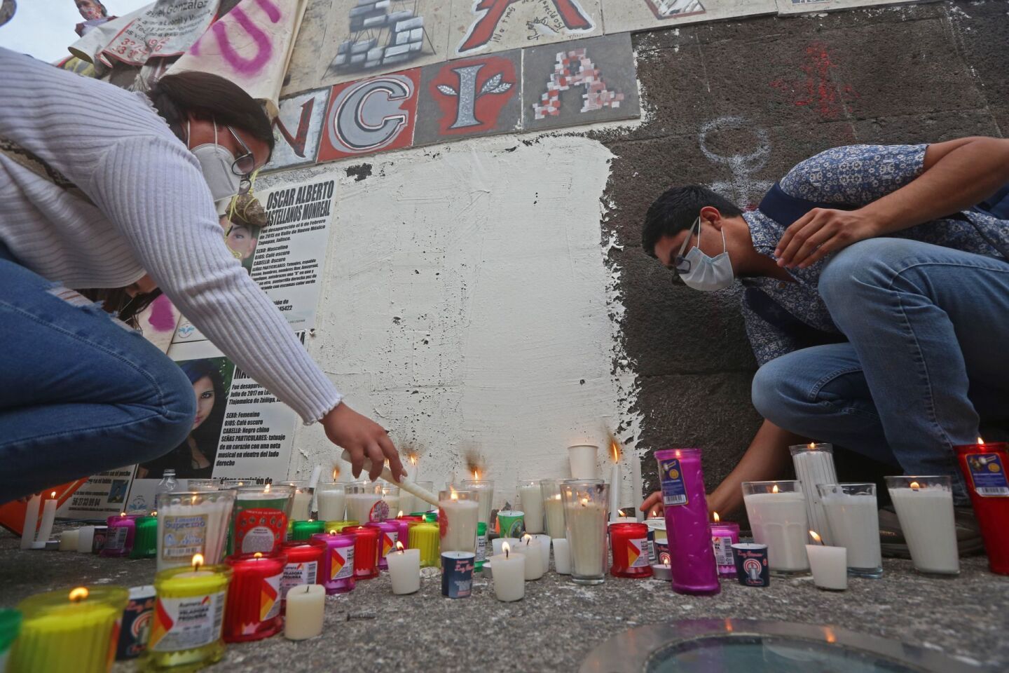 Personas prenden veladoras en la Glorieta de los desaparecidos, hoy durante la “Marcha por la Justicia y la Paz en Jalisco”.