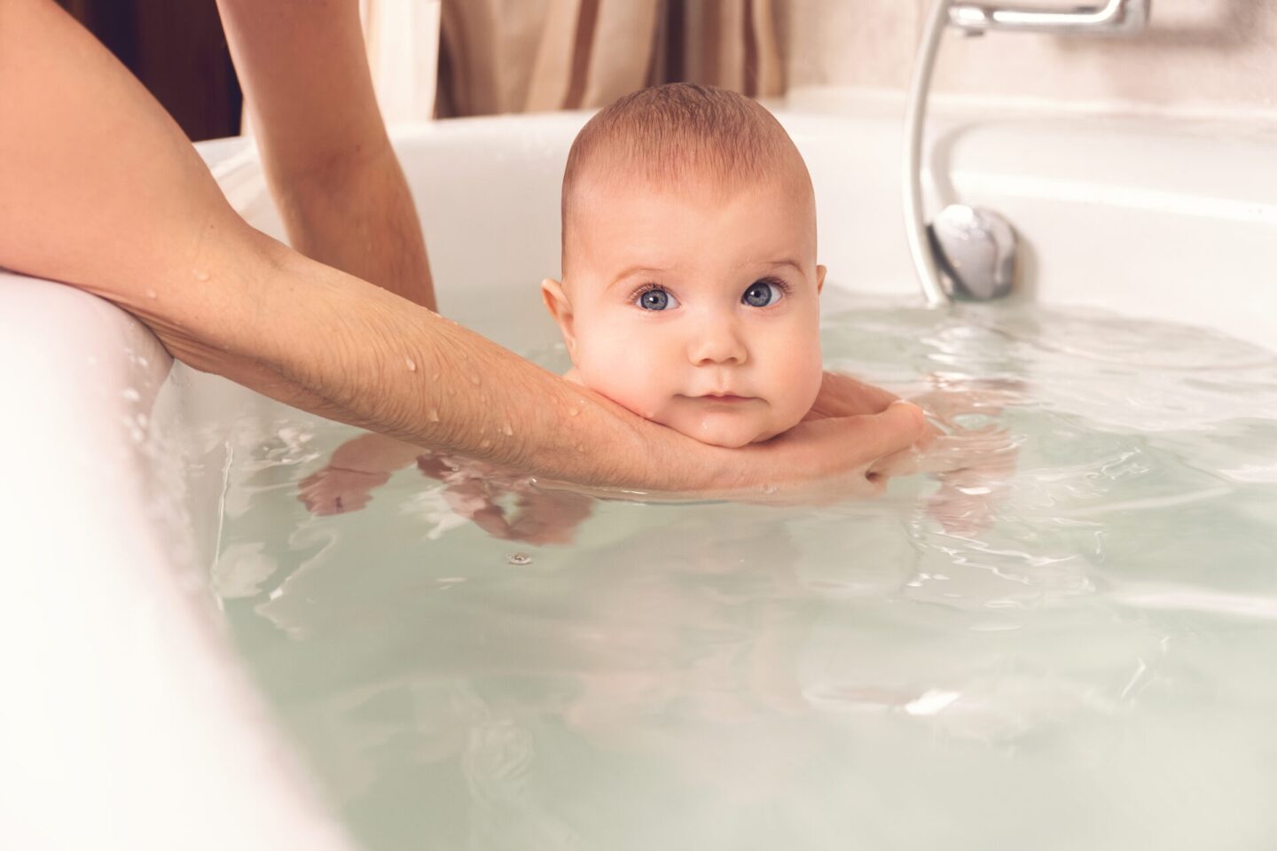 Hands of a careful unknown mother hold boy