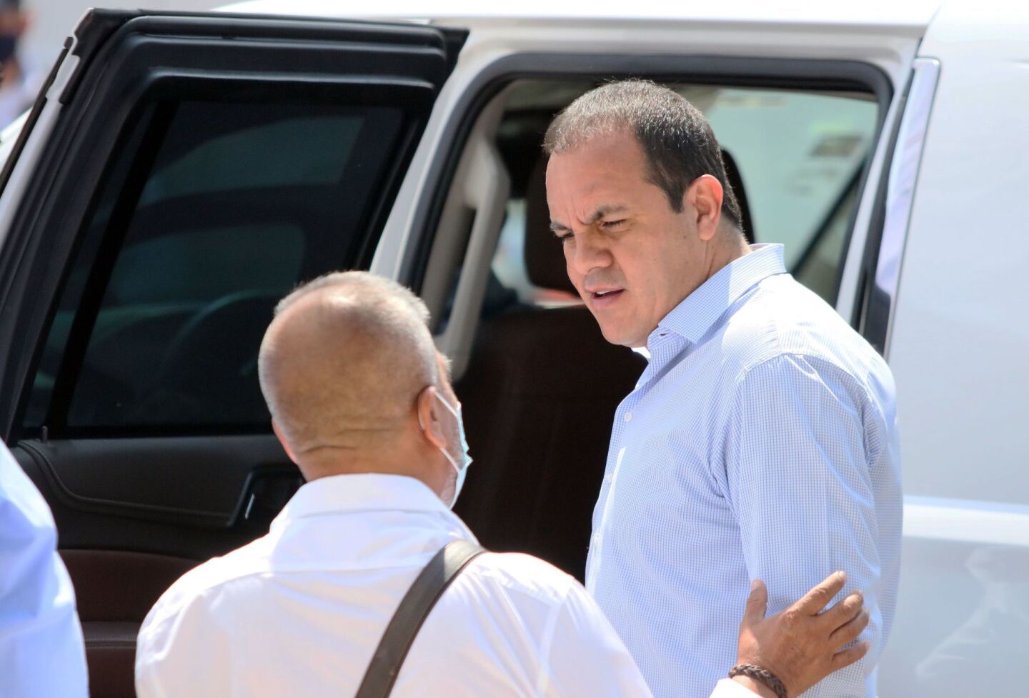 El gobernador de Morelos Cuauhtémoc Blanco Bravo platica con Francisco Reyes, vocero del gobierno, sin usar un cubre boca.
